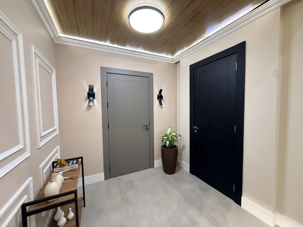 Hall com porta de giro cinza e porta preta sob teto amadeirado